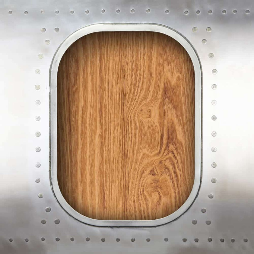 Nahaufnahme eines Flugzeugfensters mit Metallrahmen und holzverkleideter Tafel