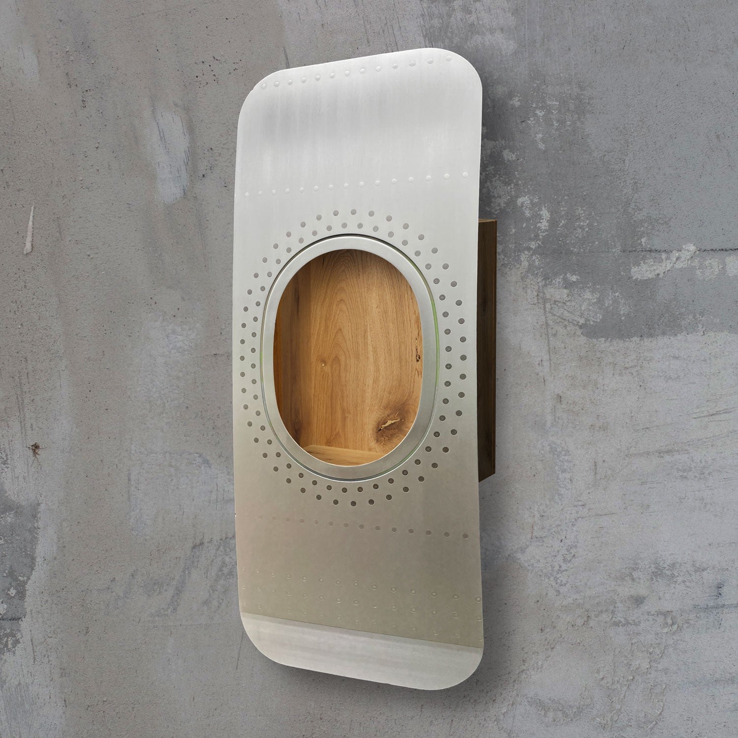 Grauer metallischer Flugzeugfensterrahmen mit Nieten und Holzstruktur an rauer Betonwand.