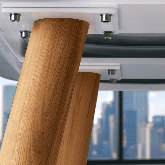 Grauer Nachttisch mit gebogenen Holzbeinen und metallischen Verbindungselementen vor Skyline.