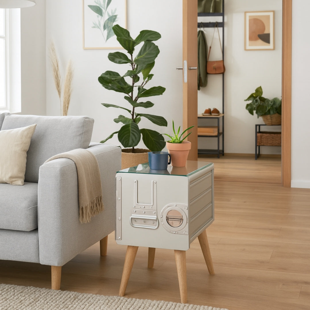 Helles Wohnzimmer mit grauem Sofa, beiger Decke, modernem Beistelltisch und großer grüner Zimmerpflanze