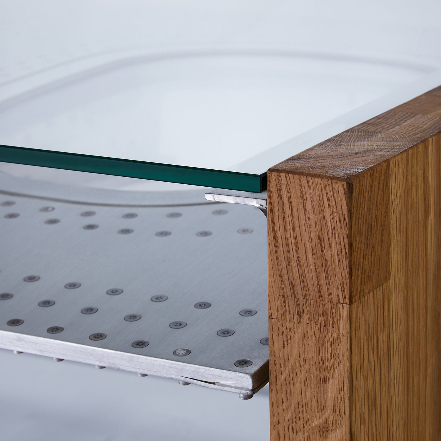 Nahaufnahme einer Holzeckverbindung mit Glasplatte und perforiertem Metallregal in modernem Design