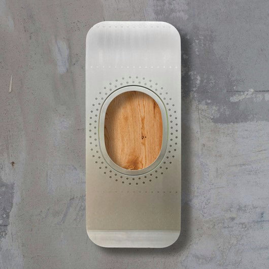 Schlankes Metallobjekt mit ovalem Holz- und Punktmuster auf grauem Hintergrund