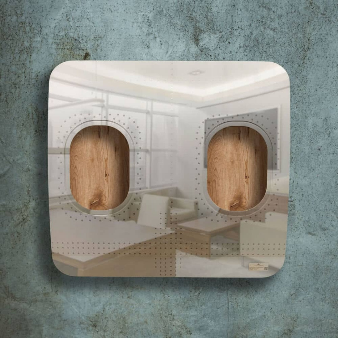 Quadratisches Metallpaneel mit ovalen Holzfenstern und Perforationen vor graublauer Wand, reflektiert Wohnzimmerszene.