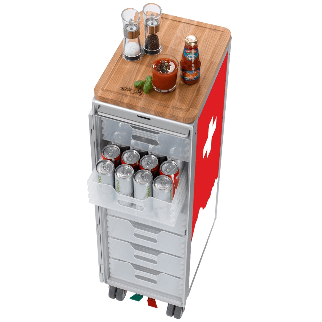 Schlanker mobiler Lagerwagen mit Holzplatte und transparenten Schubladen, gefüllt mit Getränkedosen, Salz- und Pfeffermühlen, Glas mit roten Gewürzsaucen und Lindenwald-Sauceflasche.