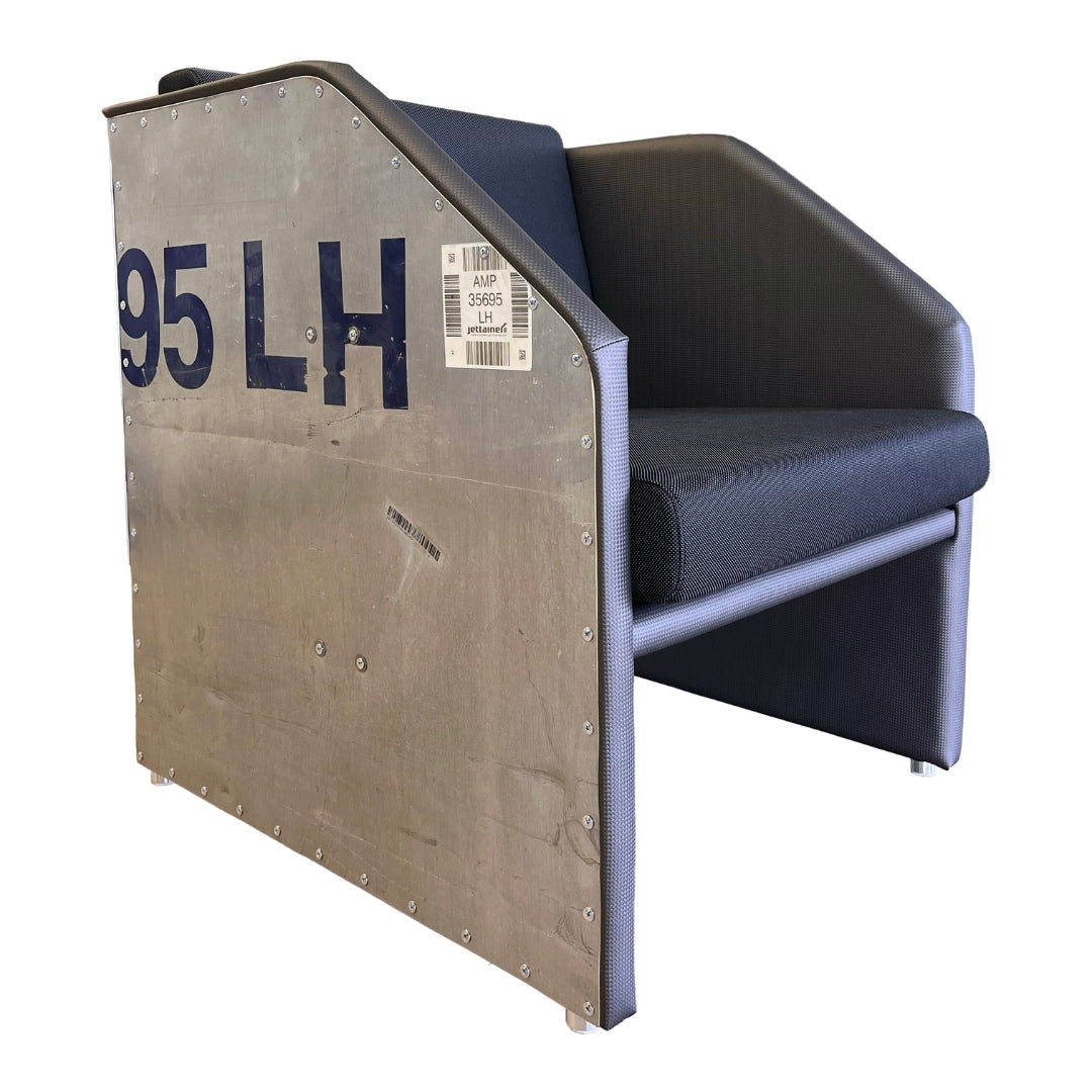 Moderner Designer-Sessel mit dunkelblauem Stoffbezug und metallener Seitenplatte im industriellen Design.