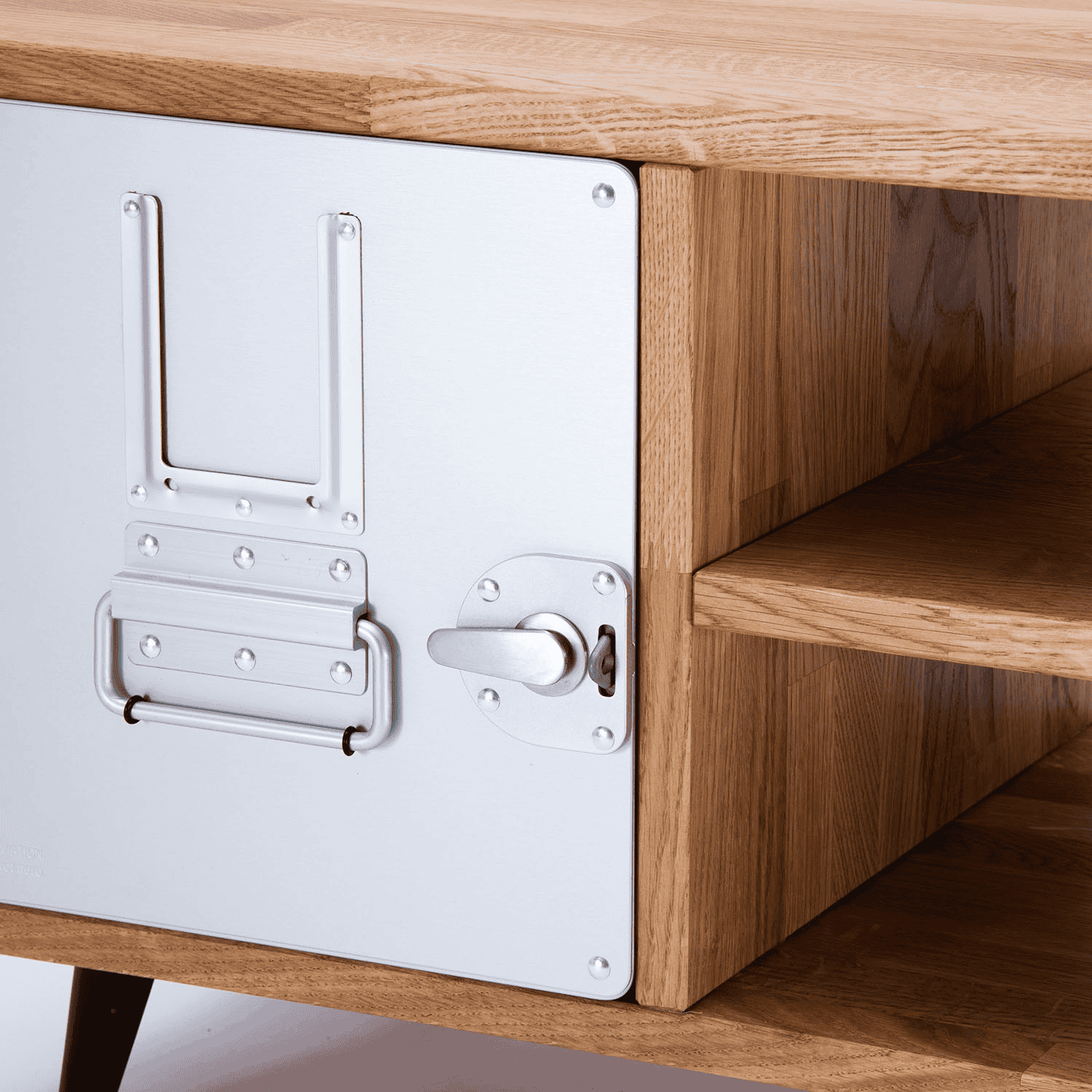 Moderner Holzschrank mit Metalltür und silbernen Nieten, kombiniert mit offenem Regal.