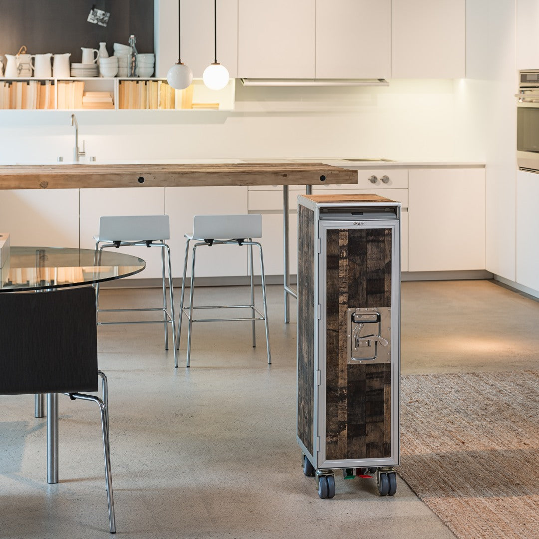 Moderner Küchenraum mit weißer Schrankwand, rustikaler Holz-Kücheninsel und mobilem Staysafe-Schrank auf Rollen.