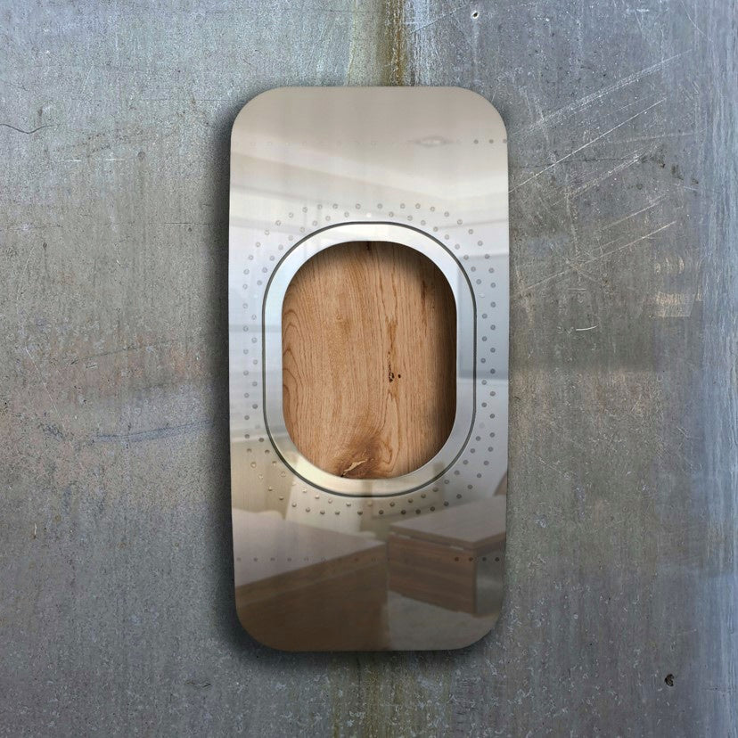 Moderner rechteckiger Metall-Wandspiegel mit abgerundeten Ecken und Holzeinlage an grauer Texturwand