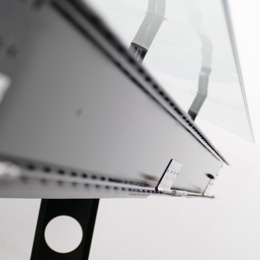 Nahaufnahme eines schwarzen Designer-Möbels aus Metall mit glänzender Oberfläche und Acrylglas.