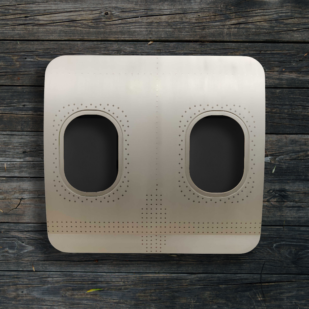 Rechteckiges Metallflugzeugfenster mit zwei ovalen Fenstern vor dunklem Holz