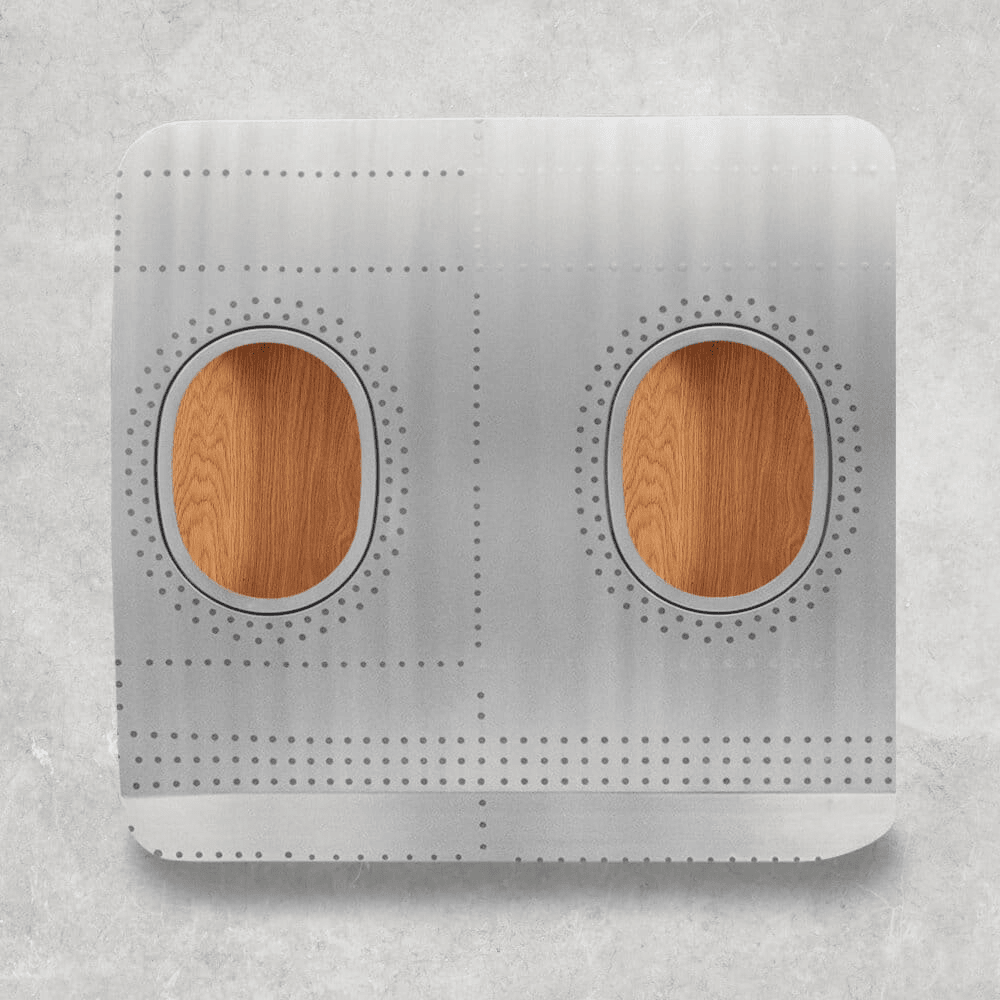 Rechteckiges Metallpaneel mit abgerundeten Ecken, durchlöcherten Nieten und ovalen Holzeinsätzen vor grauem Hintergrund
