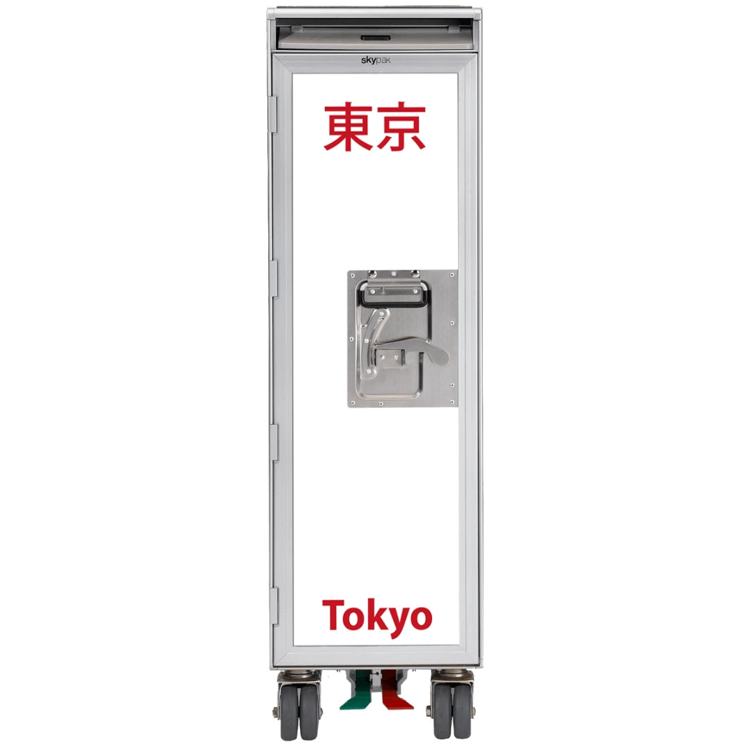 Schmaler Skypak Transporttrolley aus Metall mit weißer Fronttür, rotem Tokyo-Schriftzug und Lenkrollen.