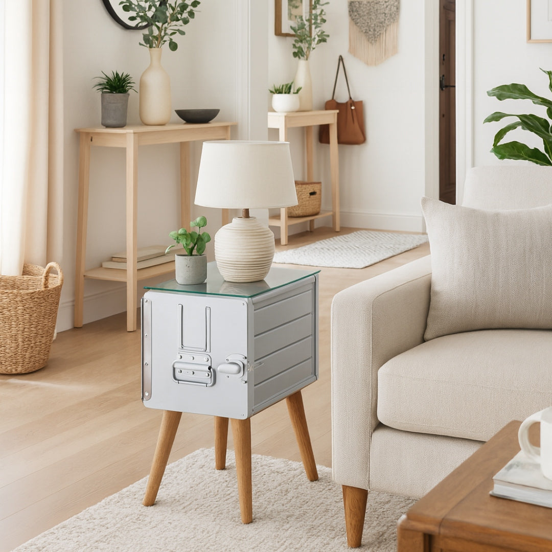 Beiger gepolsterter Sessel mit Kissen auf cremefarbenem Teppich, Beistelltisch mit Keramiklampe und Pflanzgefäß