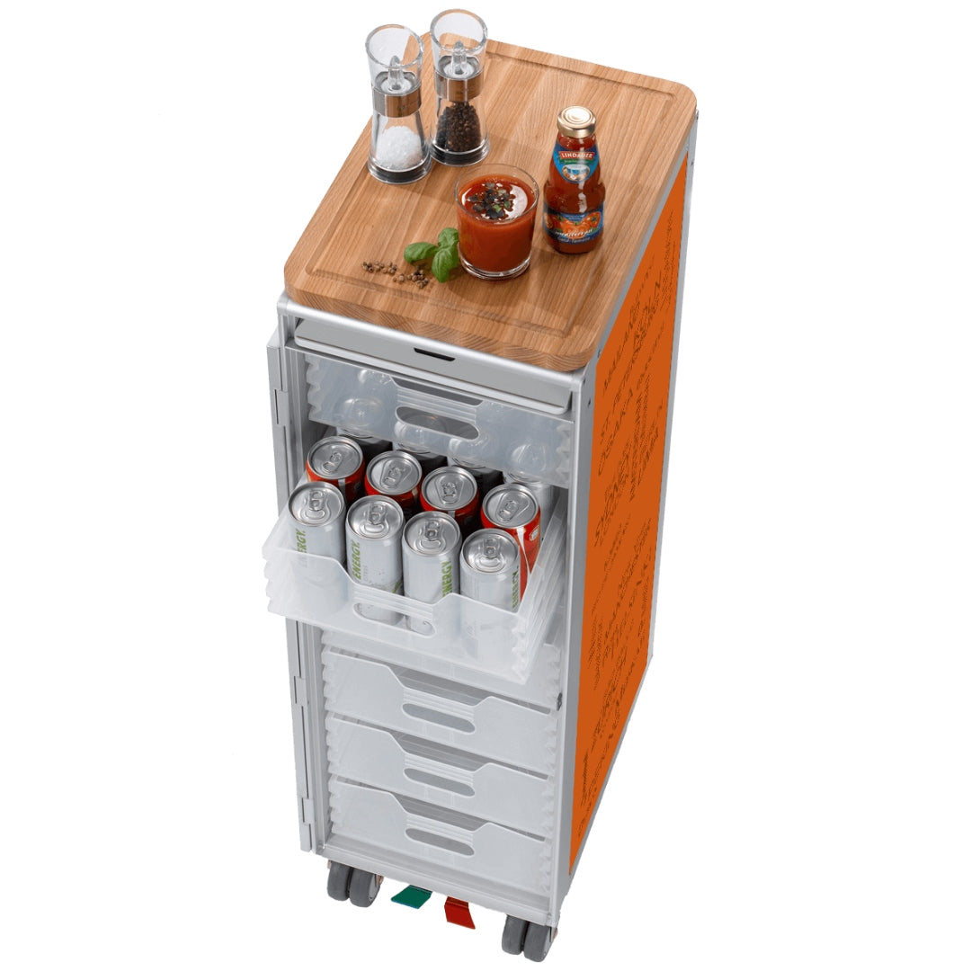 Moderner Getränkekühlschrank mit durchsichtigen Schubladen voller Energy-Drinks und Gewürzen auf einem Holzbrett.