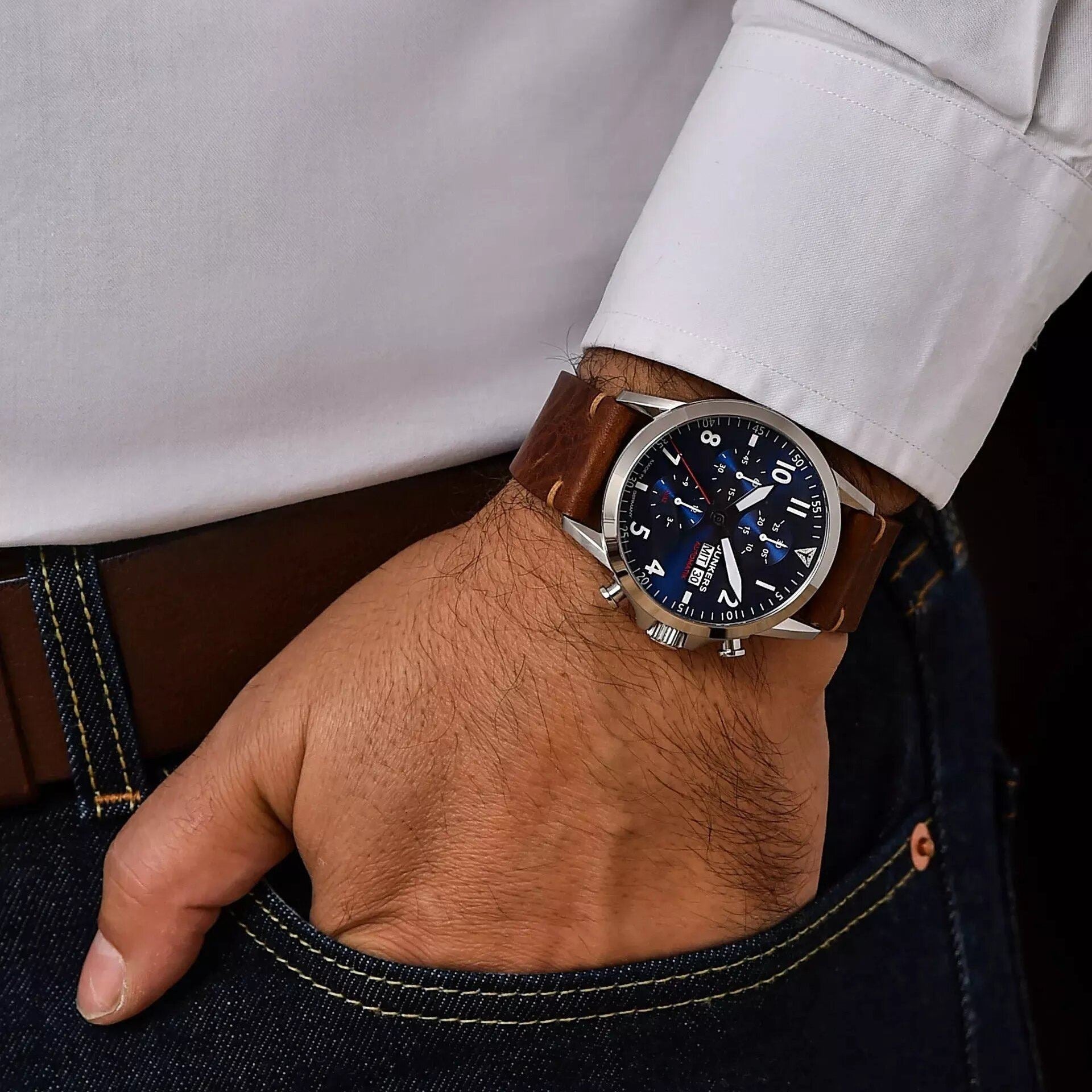 Herrenarmbanduhr Junkers 30 Automatik mit blauem Zifferblatt und braunem Lederarmband am Handgelenk.