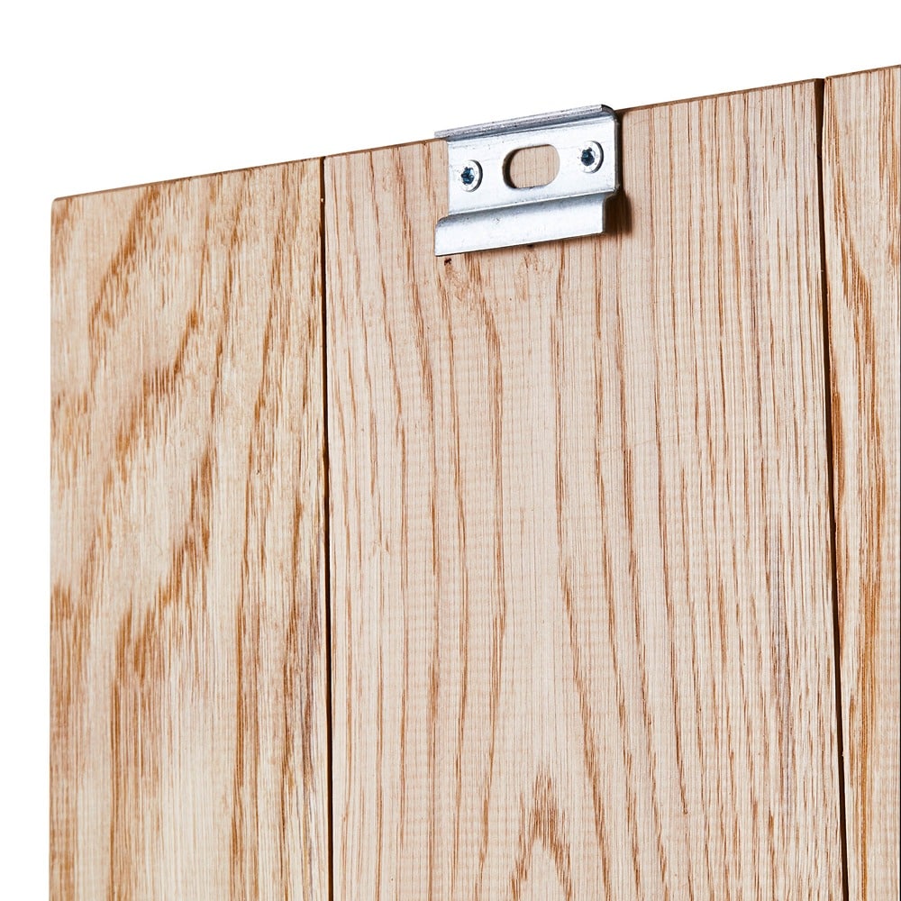 Nahaufnahme eines Holzpaneels mit drei vertikalen Brettern, Maserung und silberner Aufhängung oben.