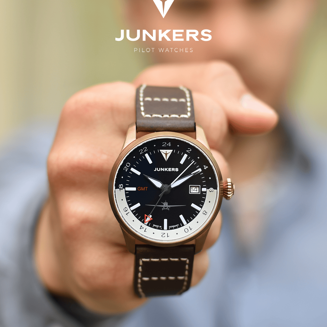 Junkers Pilotenuhr mit braunem Lederarmband und schwarzem Zifferblatt, weißer und oranger GMT-Anzeige