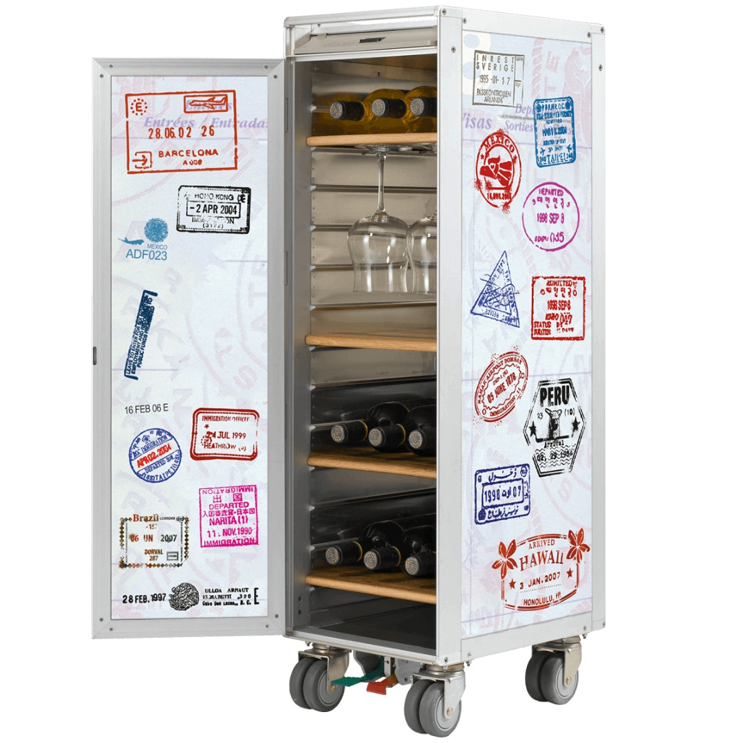 Mobiler Metallschrank mit Weinflaschen, Gläsern und bunten Reisepass-Stempeln auf Holzregalen.