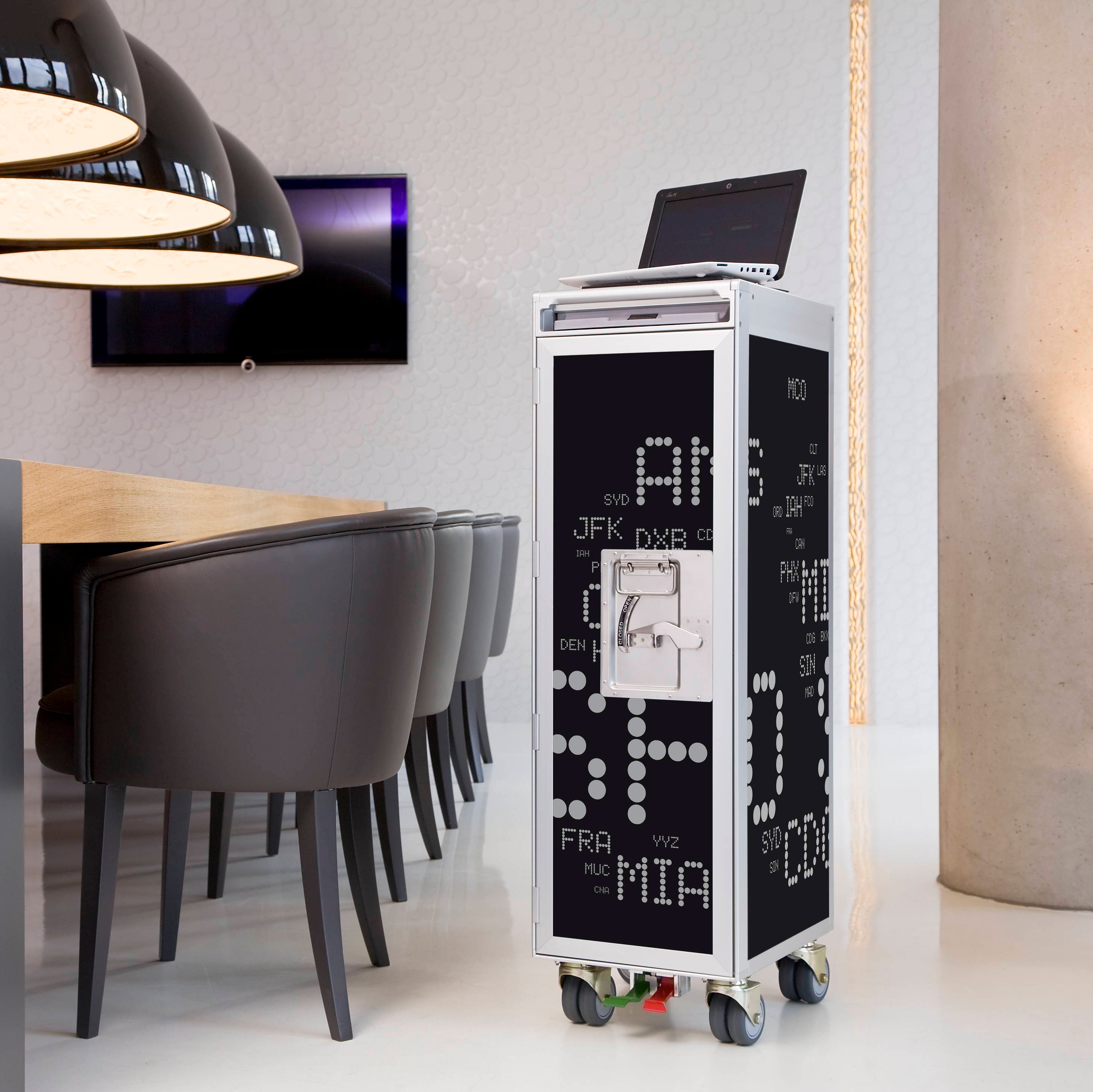 Moderner, schmaler Airport-Service-Trolley aus Flugzeugteilen mit weißen Flughafen-Codes in einem stilvollen Raum