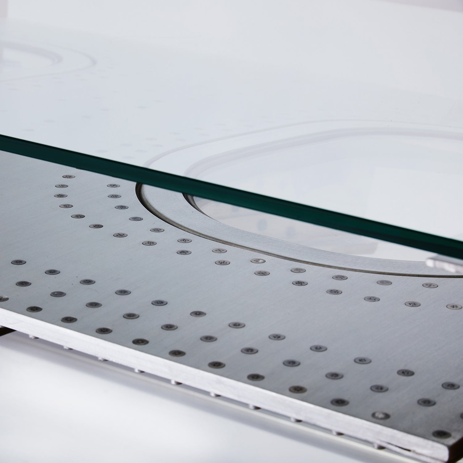 Moderner industrieller Aufbau mit Klarglasplatte und perforierter Rückwand aus gebürstetem Metall.