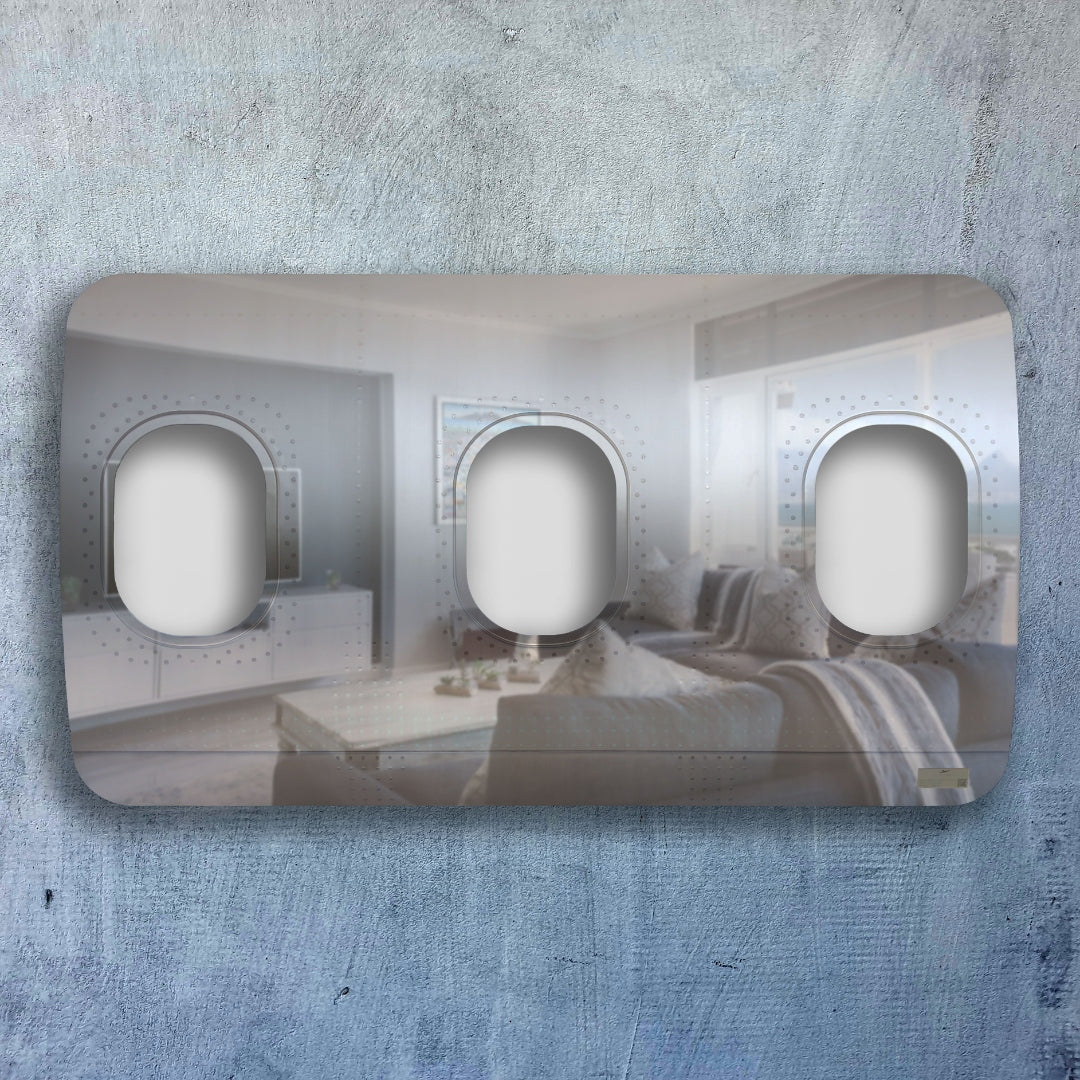 Moderner rechteckiger Lichtschalter mit drei ovalen Schaltern und spiegelnder Oberfläche, montiert an einer grauen Betonwand.