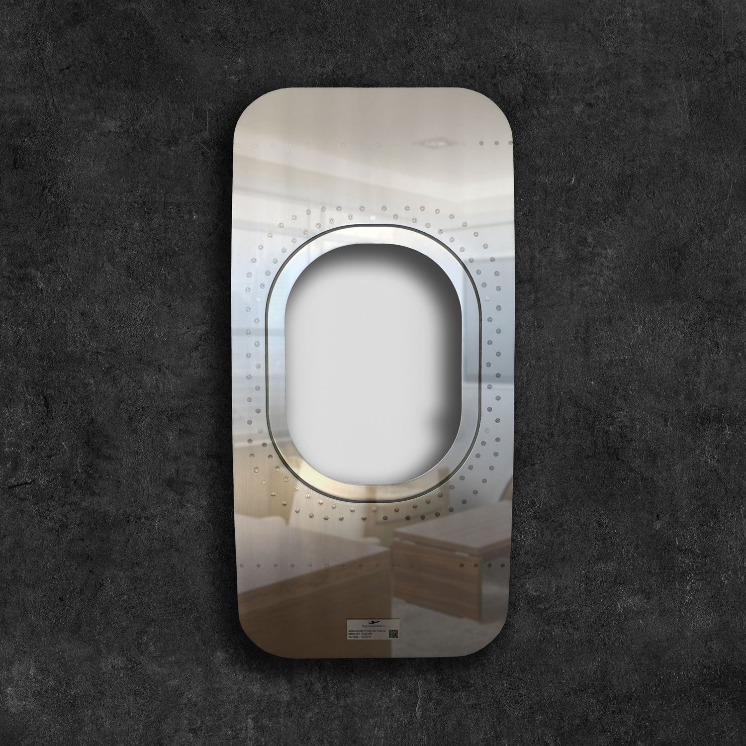 Rechteckige reflektierende Metallplatte mit ovalem Ausschnitt und Nieten auf dunklem Hintergrund