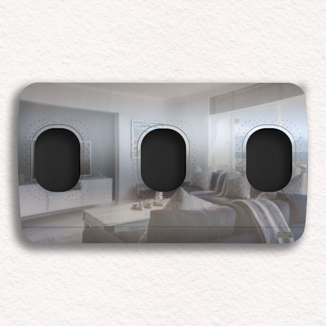 Schwarze Spiegelplatte mit drei Flugzeugfenstern und Wohnzimmerreflexion mit Sofa und Kissen